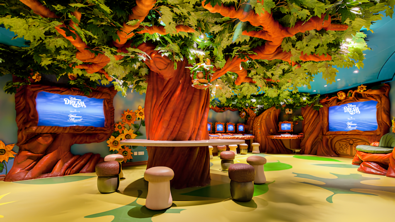 A room with a giant tree is surrounded by acorn and mushroom shaped stools, video screens and computers_Oceaneer Club (1)